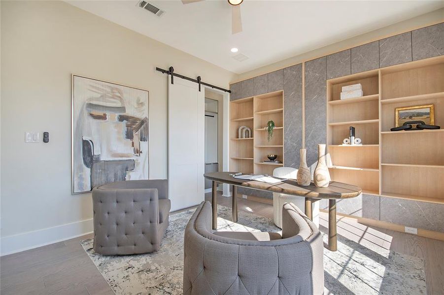 Home office with a barn door, wood finished floors, a ceiling fan, and recessed lighting Home office with a barn door, wood finished floors, a ceiling fan, and recessed lighting