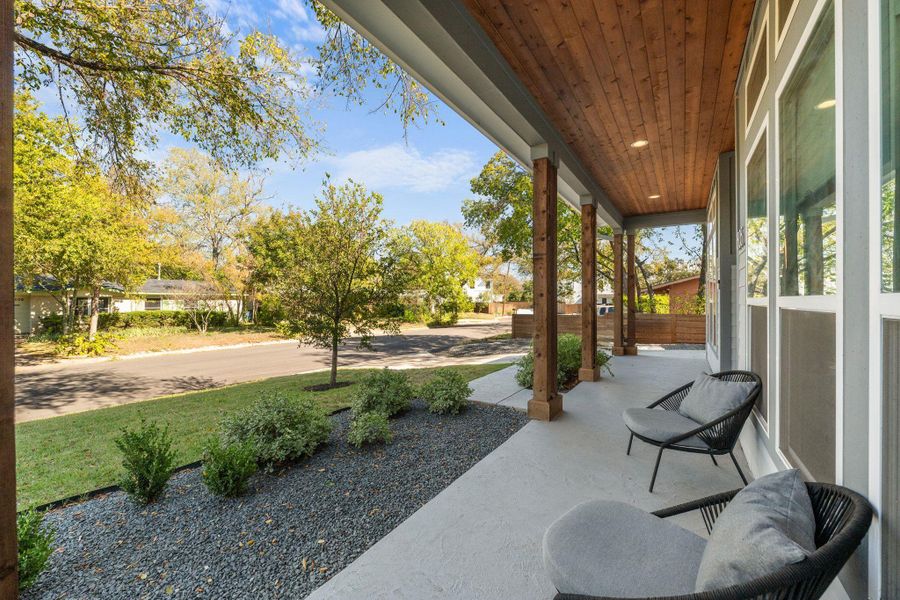 Covered porch featuring a yard
