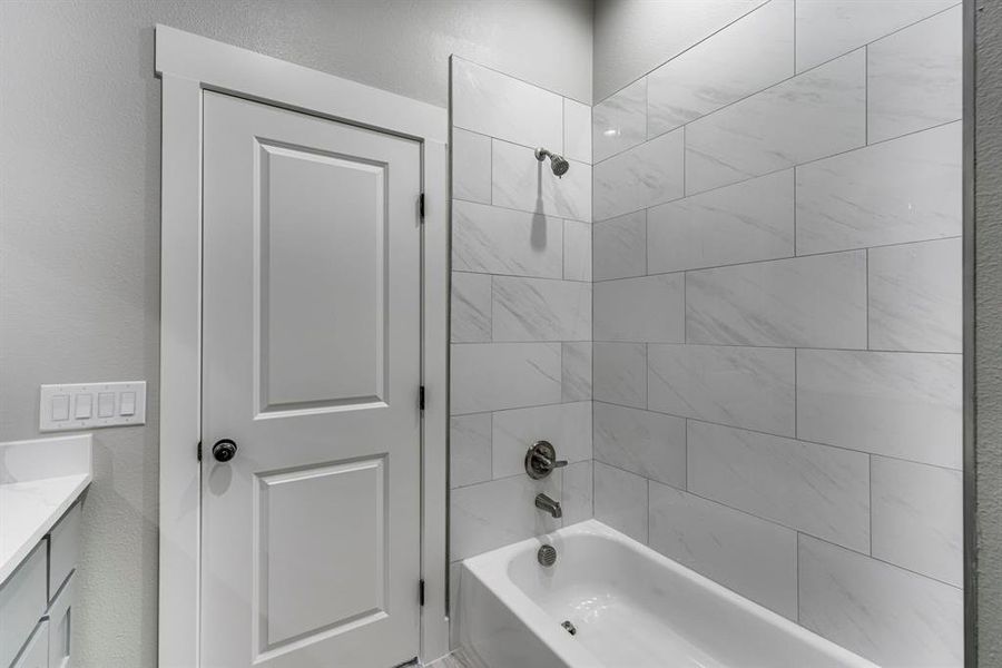 Bathroom featuring vanity and tiled shower / bath combo