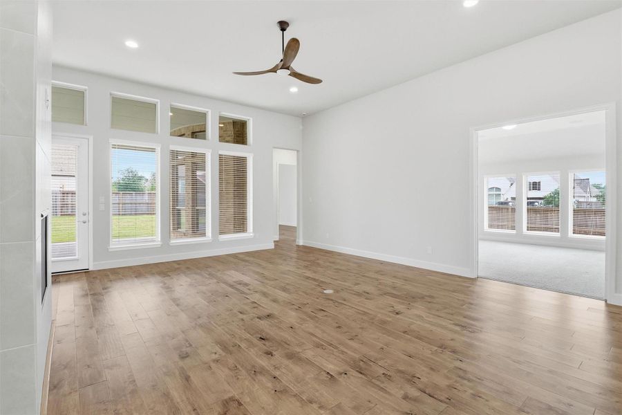 This living room was built for the way families actually live. Warm engineered hardwood floors, soaring ceilings, and a wall of windows overlooking the backyard create a space that feels open, airy, and full of light. The built-in surround sound system sets the mood effortlessly. Whether it's game day, a quiet evening, or a gathering with friends. And just off the living room? A generous flex space the current owners transformed into a dedicated movie room, equipped with surround sound speakers.