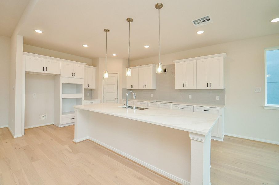 Notice the huge island that offers extra seating for casual meals, also notice the light pendants that hang above. Notice the huge island that offers extra seating for casual meals, also notice the light pendants that hang above.