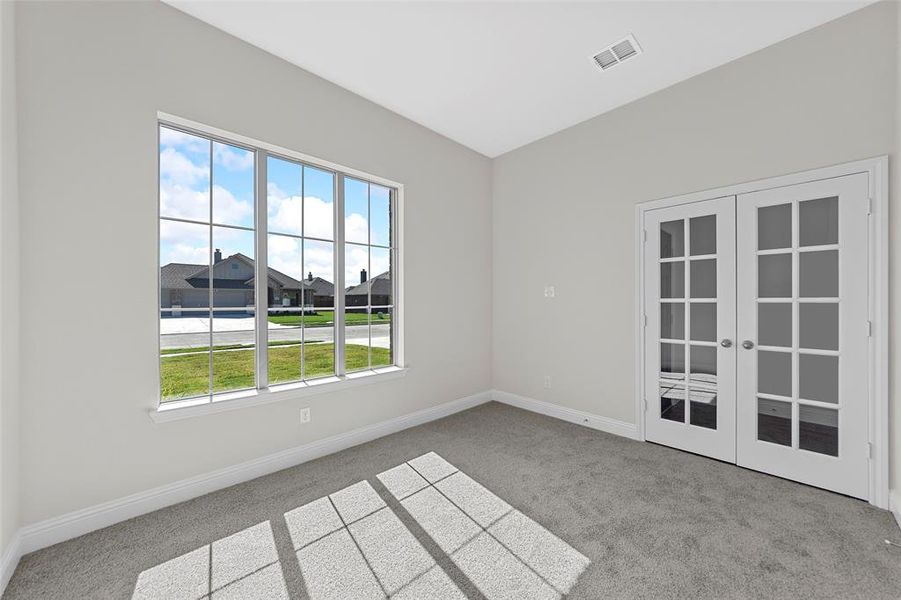 Unfurnished room featuring french doors and light carpet