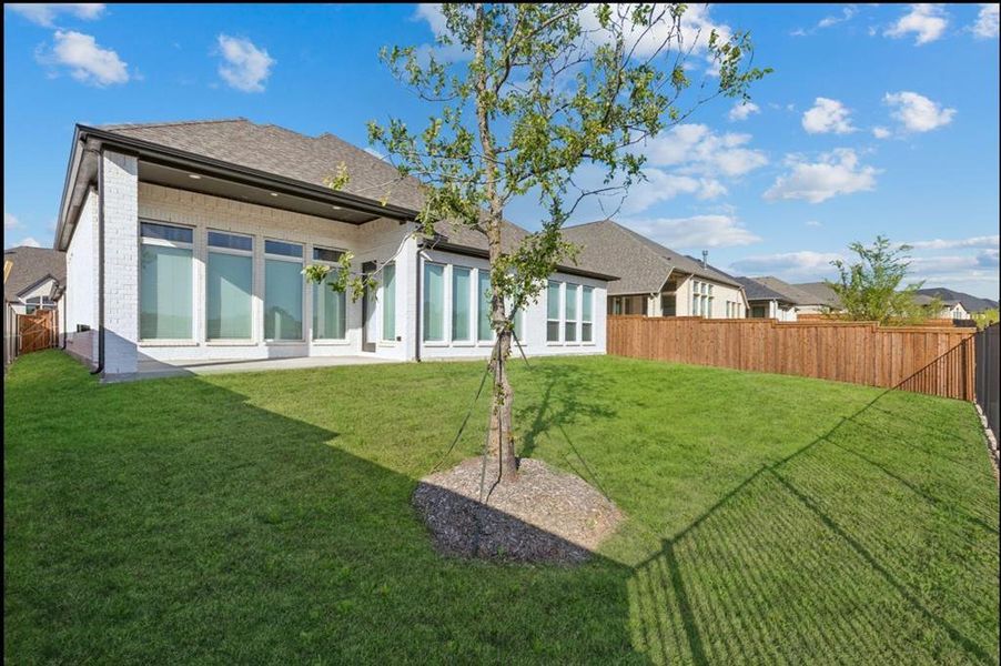 Rear view of property featuring a fenced backyard, brick siding, a patio area, and a shingled roof