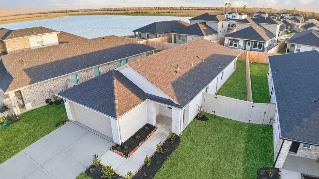 An aerial view of the newly built one story home with traditional architecture, a two car garage and a landscaped front yard