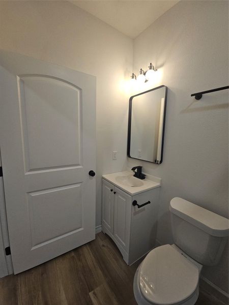 Bathroom featuring toilet, wood finished floors, and vanity