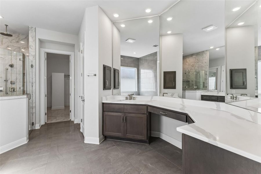 Marble accents and a spacious walk-in shower elevate this primary bathroom's comfort.