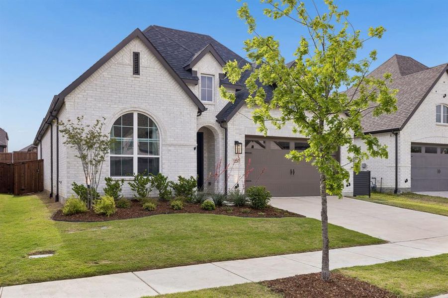 White brick exterior with dark trim and an arched window