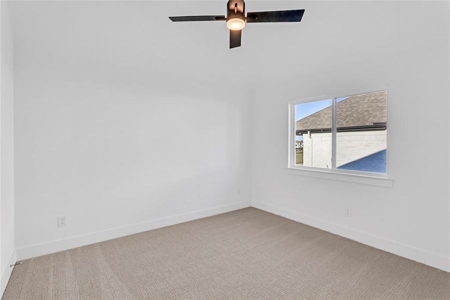 Empty room with light colored carpet and baseboards