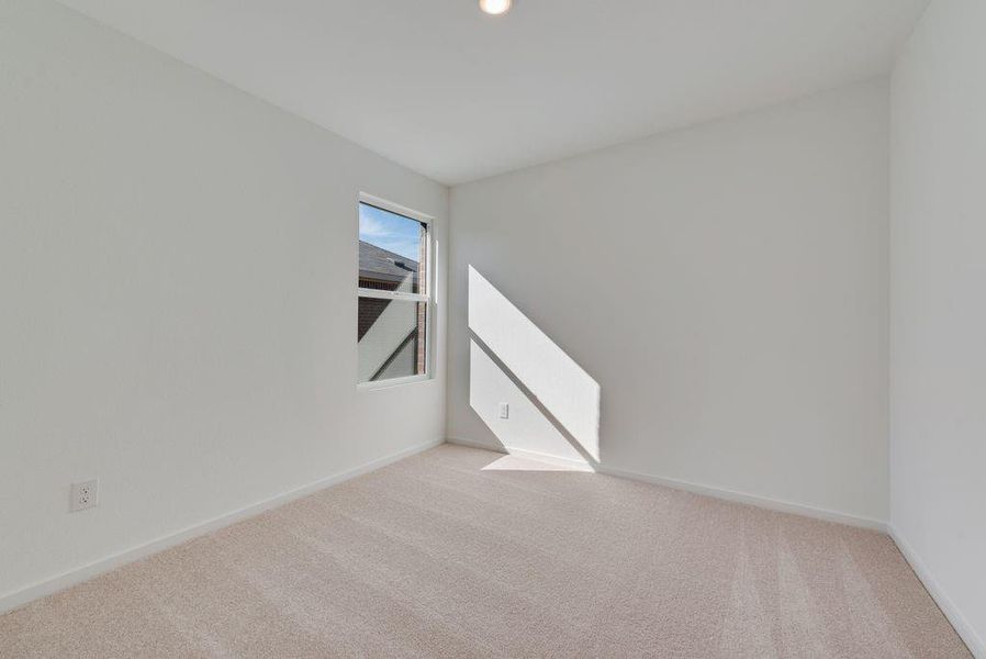Carpeted empty room featuring baseboards