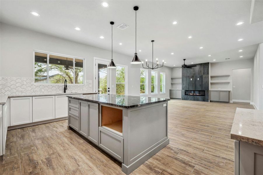 Kitchen with a fireplace, a sink, visible vents, light wood-style floors, and gray cabinets