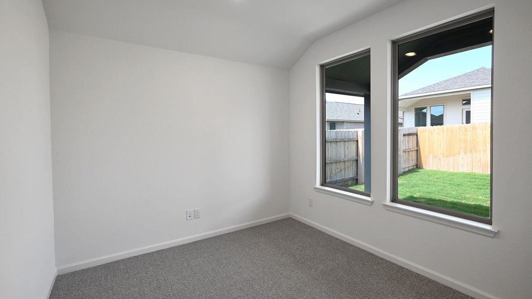 Carpeted spare room with baseboards and lofted ceiling Carpeted spare room with baseboards and lofted ceiling