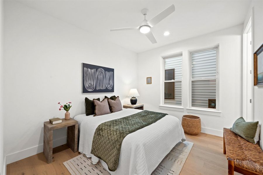 Hardwood floors and bright windows illuminate this cozy bedroom. Hardwood floors and bright windows illuminate this cozy bedroom.