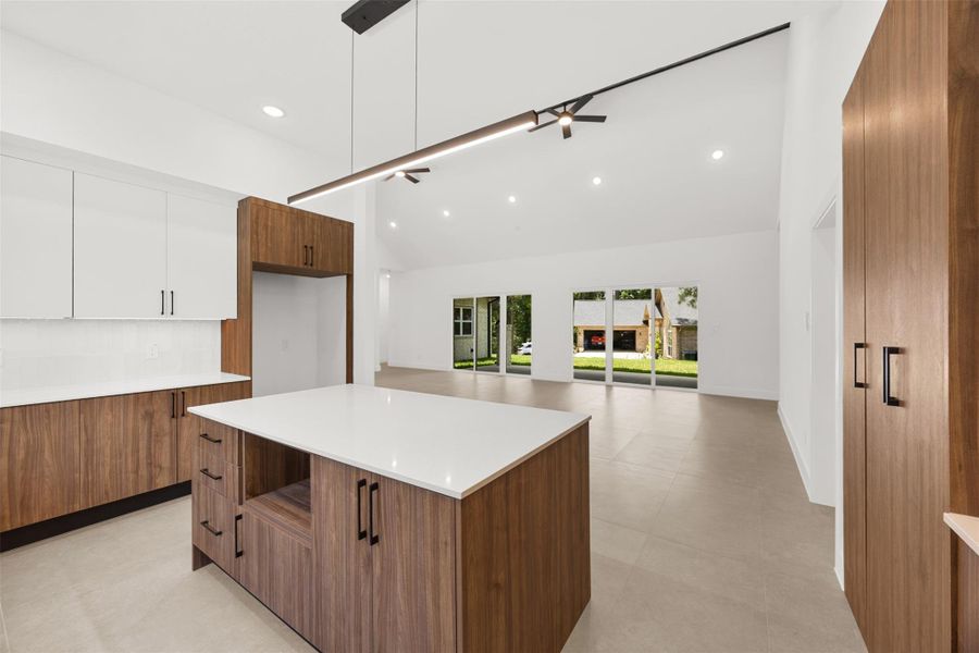 Open-concept kitchen overlooking the spacious living room with vaulted ceiling