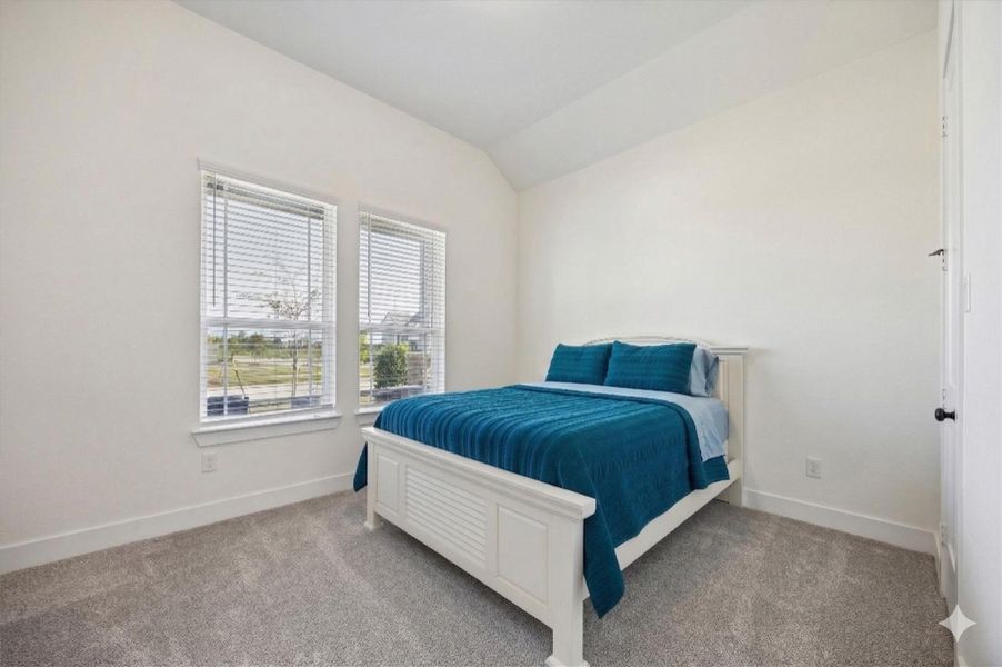 One of three secondary bedrooms featuring neutral tones and large windows with blinds for plenty of natural light. This comfortable space includes upgraded carpeting and a ceiling fan, perfect for family or guests. One of three secondary bedrooms featuring neutral tones and large windows with blinds for plenty of natural light. This comfortable space includes upgraded carpeting and a ceiling fan, perfect for family or guests.