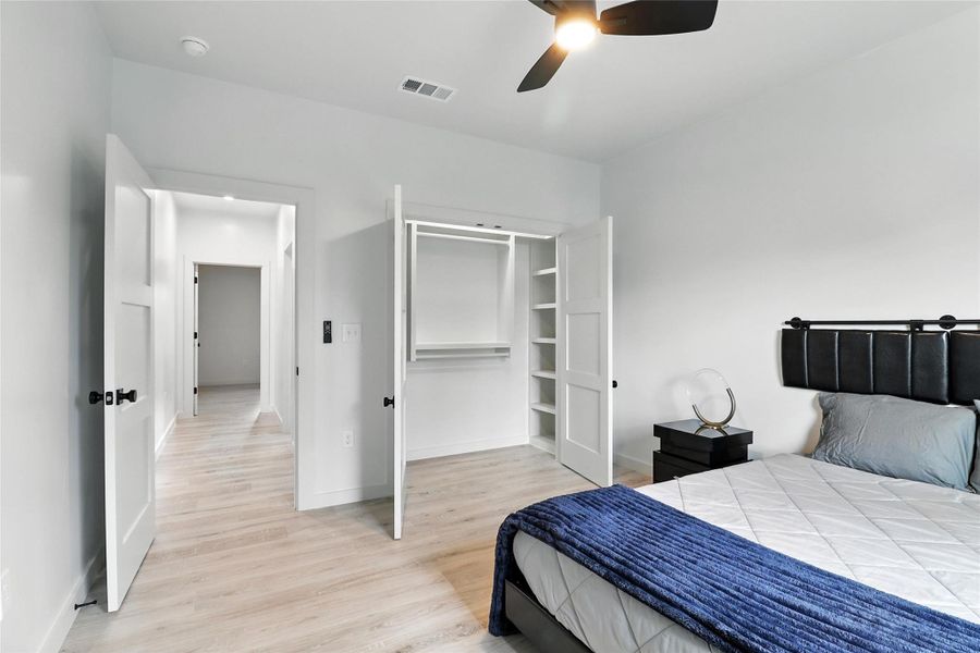 Bedroom with light wood finished floors, a closet, and ceiling fan