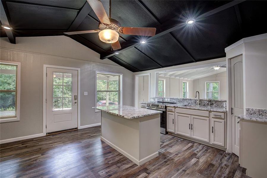 Kitchen with electric stove, sink, ceiling fan, and dark hardwood / wood-style floors