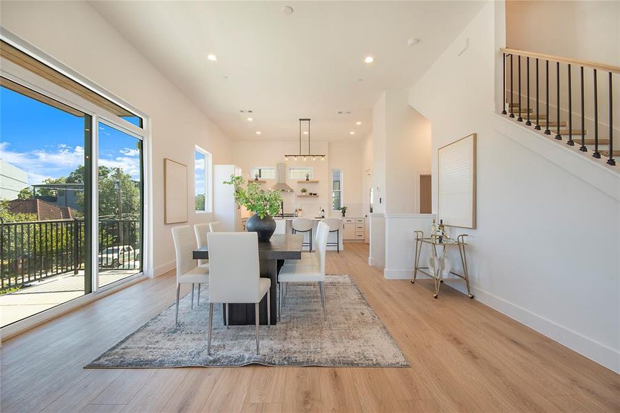 Dining space featuring recessed lighting, light wood-style floors, and stairway Dining space featuring recessed lighting, light wood-style floors, and stairway