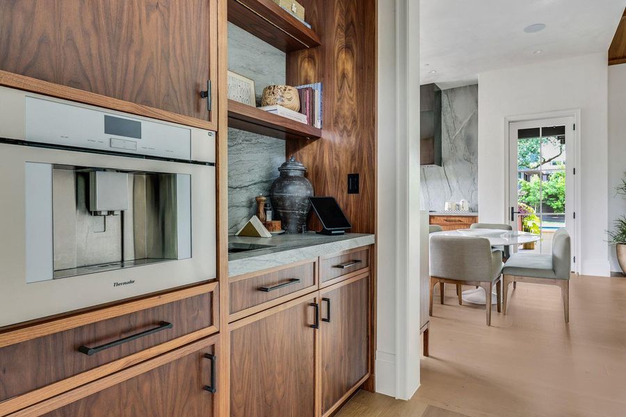 The butler's panty, with integrated Thermador coffee maker leads seamlessly into the kitchen from the dining room.