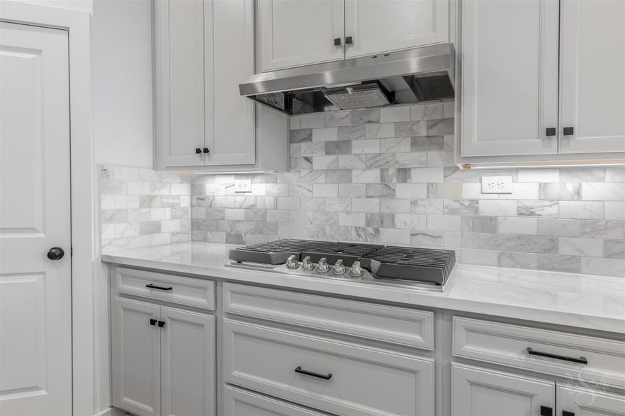 A professional-grade gas cooktop is set against a stunning gorgeous backsplash, creating a refined focal point for the heart of the home. Perfect for cooking gourmet meals, this beautifully lit workspace combines high-end function with timeless style. A professional-grade gas cooktop is set against a stunning gorgeous backsplash, creating a refined focal point for the heart of the home. Perfect for cooking gourmet meals, this beautifully lit workspace combines high-end function with timeless style.