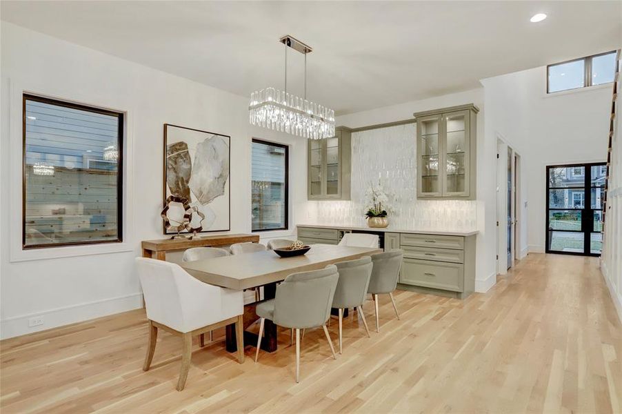 Open Dining Room offers flexibility for table size and shape.  Crystal chandelier, under cabinet lighting and glass doors with lit glass shelves.