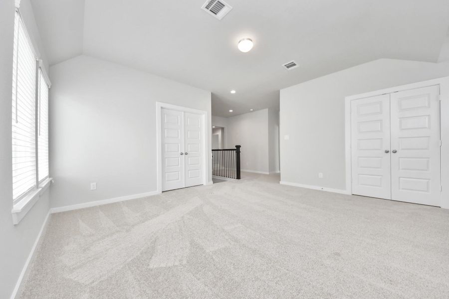 Discover a haven of leisure in this fantastic game room! Whether you're seeking a casual hangout or an adult gaming retreat, this space has it all. Enjoy the luxurious feel of plush carpet underfoot, the expansive ambiance of high ceilings, custom paint that adds a touch of personality, and windows that flood the room with refreshing natural light. Sample photo of completed home with similar floor plan. Actual colors and selections may vary.