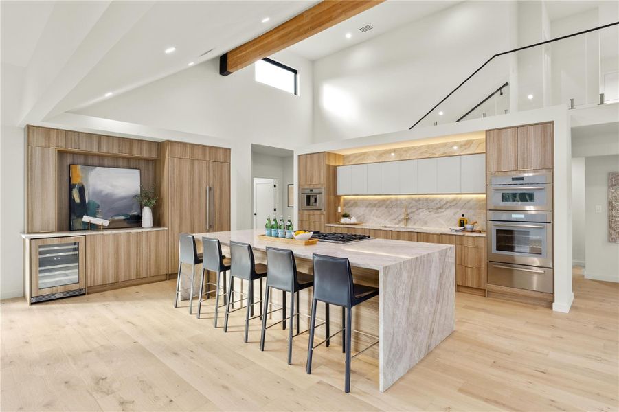 Kitchen with modern cabinets, wine cooler, a warming drawer, high vaulted ceiling, and a kitchen breakfast barThermador appliances