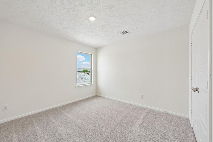 Well appointed secondary bedroom that features plush carpeting, neutral paint tones, recessed lighting, large window, and a generously sized closet.