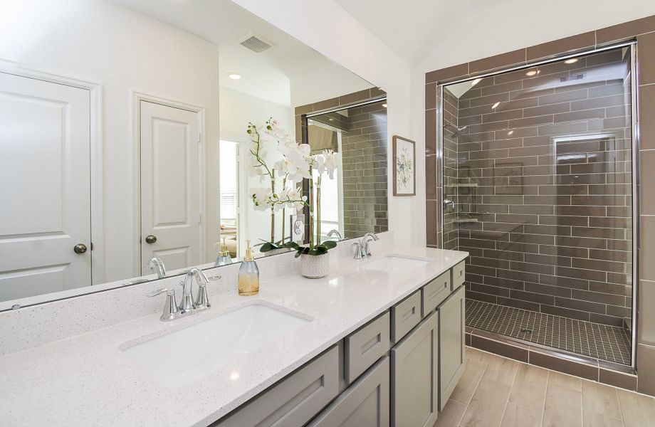 A luxurious bathroom featuring a walk-in shower with glass doors and premium finishes.