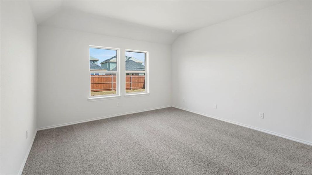 Bright room featuring two large windows, neutral gray carpet, white baseboards, and a vaulted ceiling