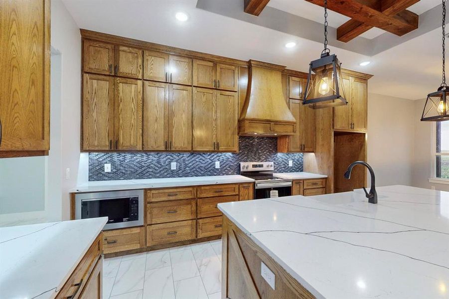 Kitchen with tasteful backsplash, premium range hood, stainless steel appliances, pendant lighting, and beamed ceiling