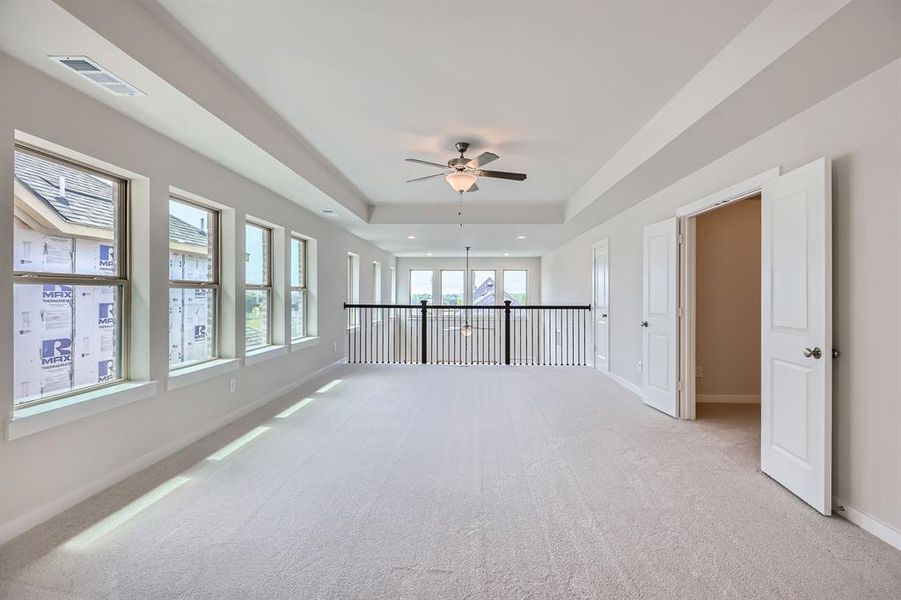 Spare room with light carpet, a raised ceiling, a ceiling fan, and recessed lighting