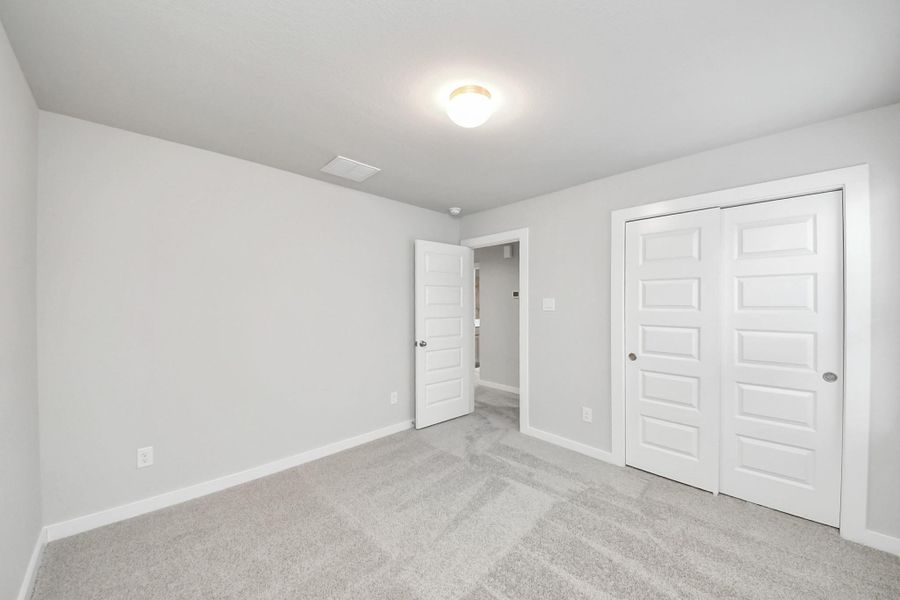 Generously sized secondary bedrooms featuring spacious closets, soft and inviting carpeting underfoot, large windows allowing plenty of natural light, and the added touch of privacy blinds for your personal retreat. Sample photo of completed home with similar floor plan. Actual colors and selections may vary.