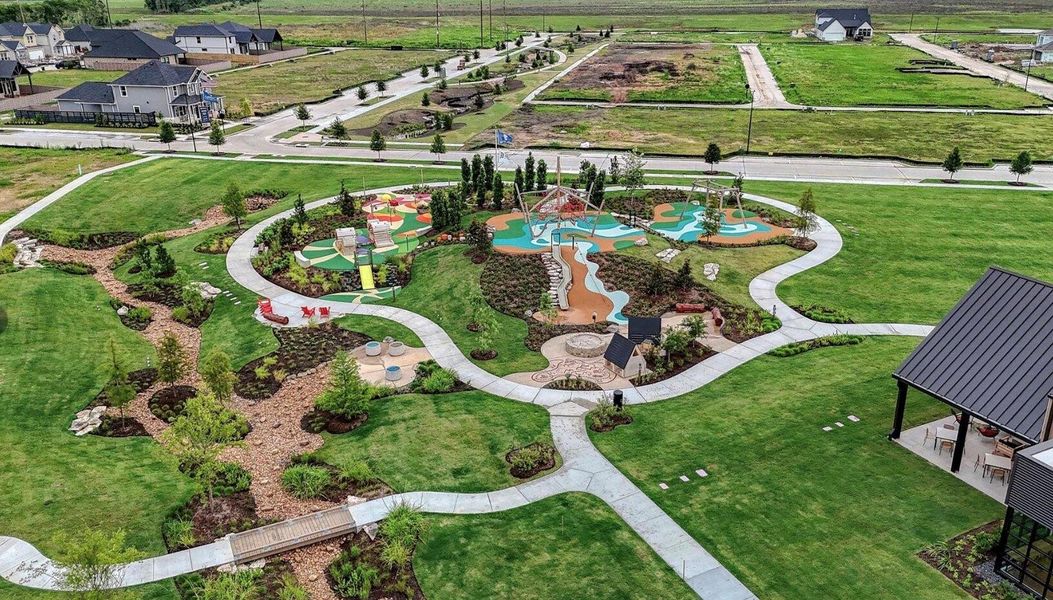 Aerial view of The 1824 at Austin Point, showcasing the community’s lush green space, children’s play area, inviting gathering spaces, walking paths, and expansive event lawn.