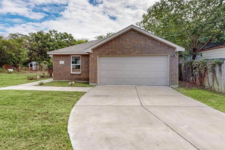 View of front of property with a garage and a front lawn