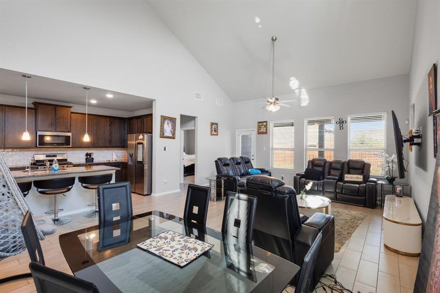 Dining space featuring high vaulted ceiling and a ceiling fan Dining space featuring high vaulted ceiling and a ceiling fan