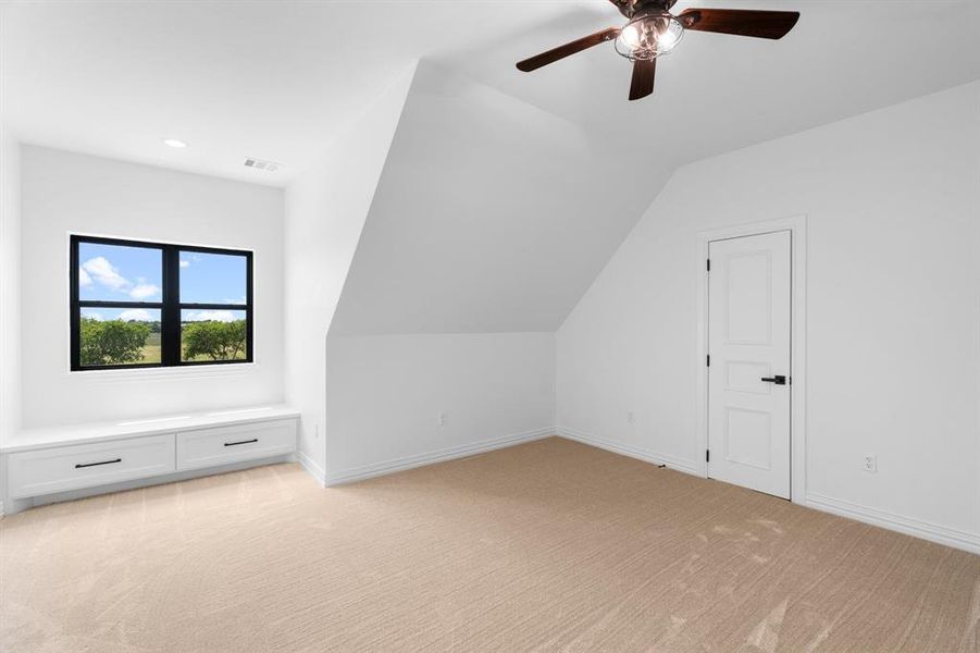 Bonus room featuring light carpet, lofted ceiling, and ceiling fan Bonus room featuring light carpet, lofted ceiling, and ceiling fan