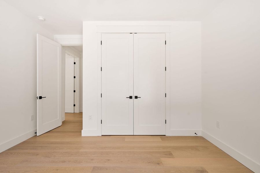 Unfurnished bedroom with light wood-type flooring and a closet Unfurnished bedroom with light wood-type flooring and a closet