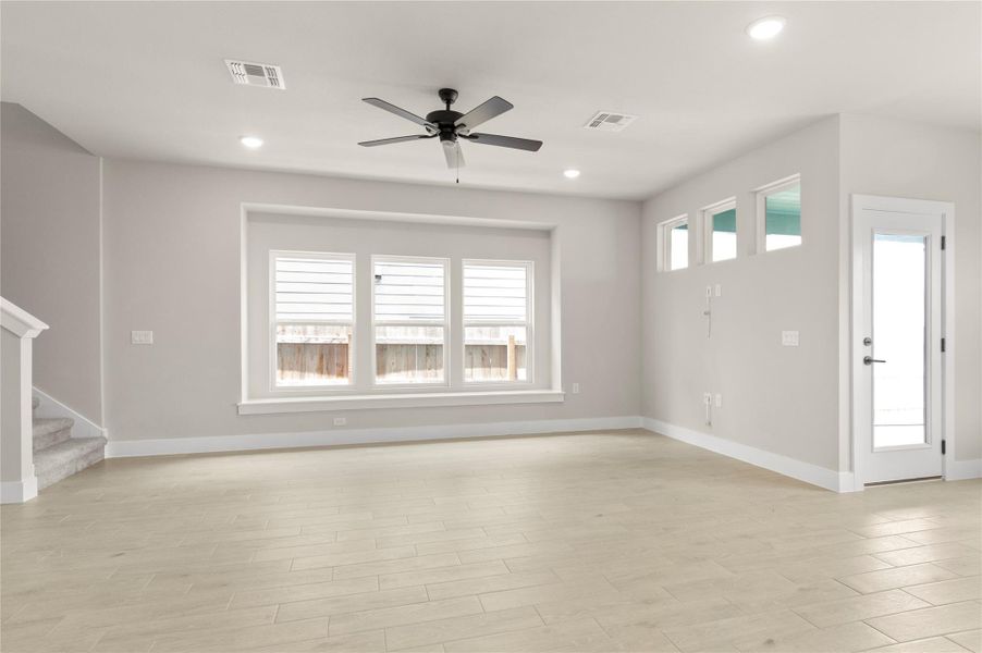 Unfurnished living room featuring a ceiling fan, stairs, baseboards, recessed lighting, and light wood-style floors Unfurnished living room featuring a ceiling fan, stairs, baseboards, recessed lighting, and light wood-style floors