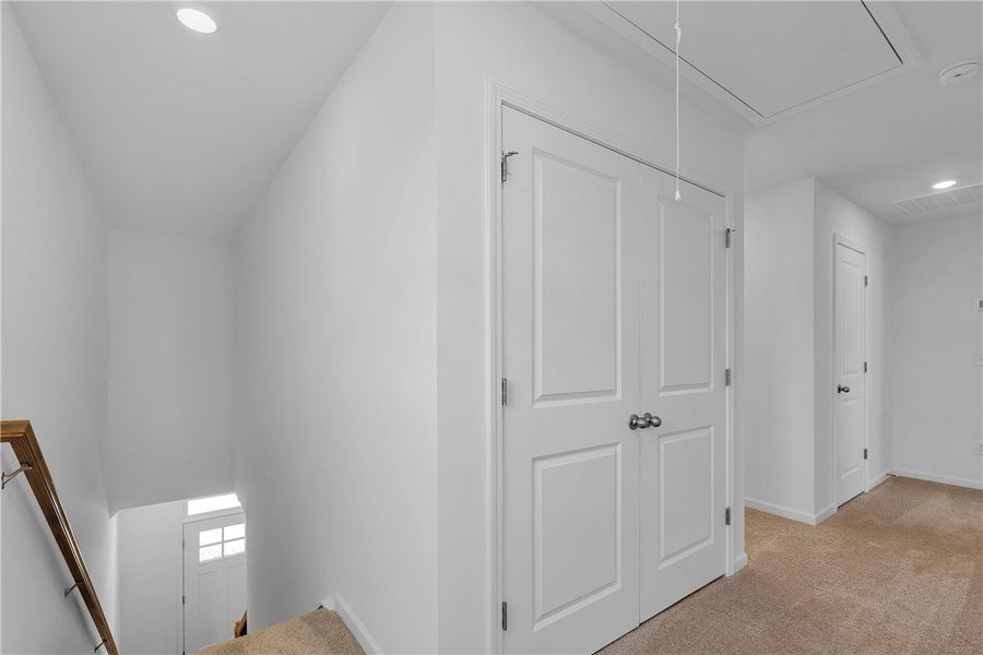 This interior hallway features carpet flooring and