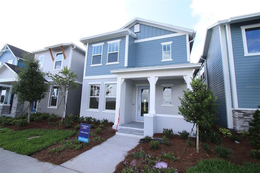 Front exterior of a new home in Laureate Park at Lake Nona - Garden Series, Orlando, FL, highlighting curb appeal (Image 12). Front exterior of a new home in Laureate Park at Lake Nona - Garden Series, Orlando, FL, highlighting curb appeal (Image 12).