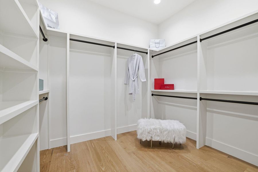 Walk in closet with light wood finished floors