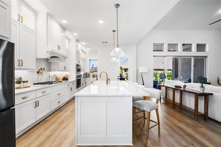 ophisticated kitchen showcasing ceiling-height cabinetry, statement gold hardware, and a polished, high-end aesthetic.