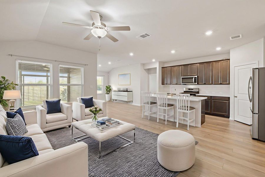 Living room featuring light wood-style floors, lofted ceiling, ceiling fan, and recessed lighting Living room featuring light wood-style floors, lofted ceiling, ceiling fan, and recessed lighting