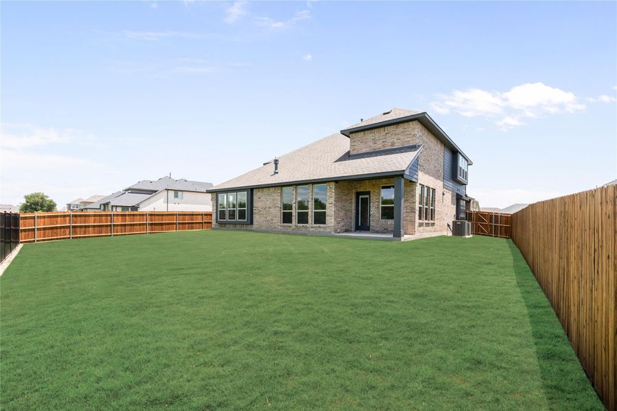 Two-story brick home with large fenced backyard, covered patio, and green lawn Two-story brick home with large fenced backyard, covered patio, and green lawn