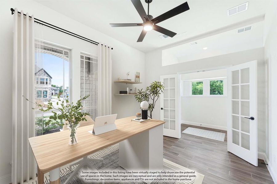 Home office with wood desk, ceiling fan, French doors, and large windows with natural light