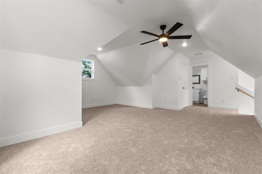 This versatile room features neutral-toned carpeting, a window providing natural light, and a ceiling fan