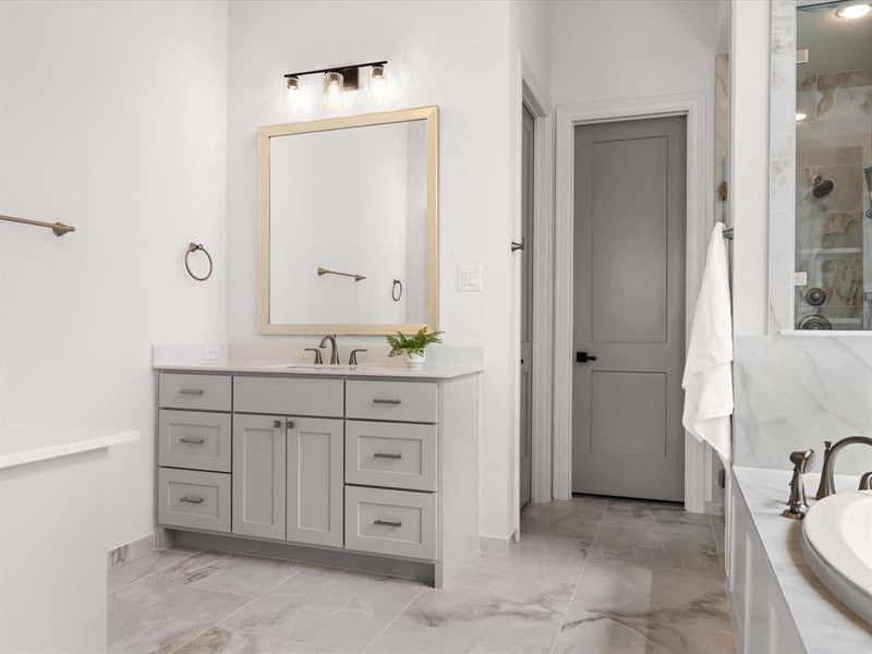 Full bath featuring vanity, a shower stall, light marble finish floors, and a garden tub
