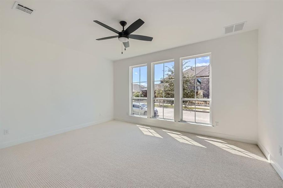 Carpeted spare room with ceiling fan