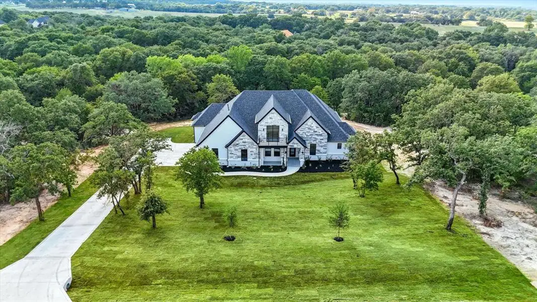 Aerial view of property and surrounding area with a forest Aerial view of property and surrounding area with a forest