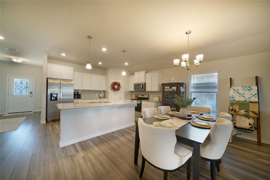 Dining space with plenty of natural light, dark wood-type flooring, a chandelier, and recessed lighting